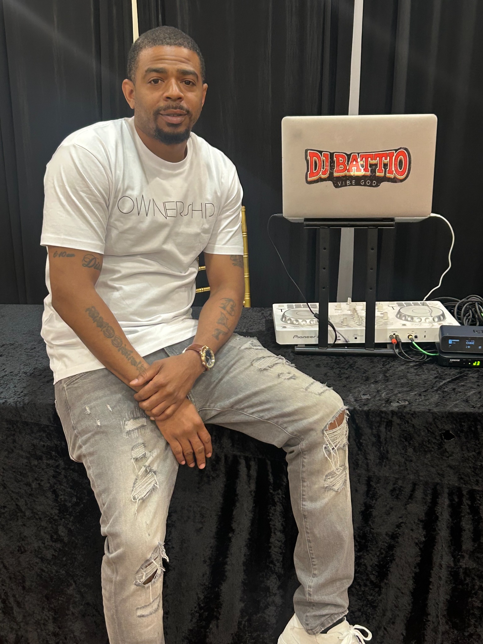 DJ Battio behind the DJ booth at an event