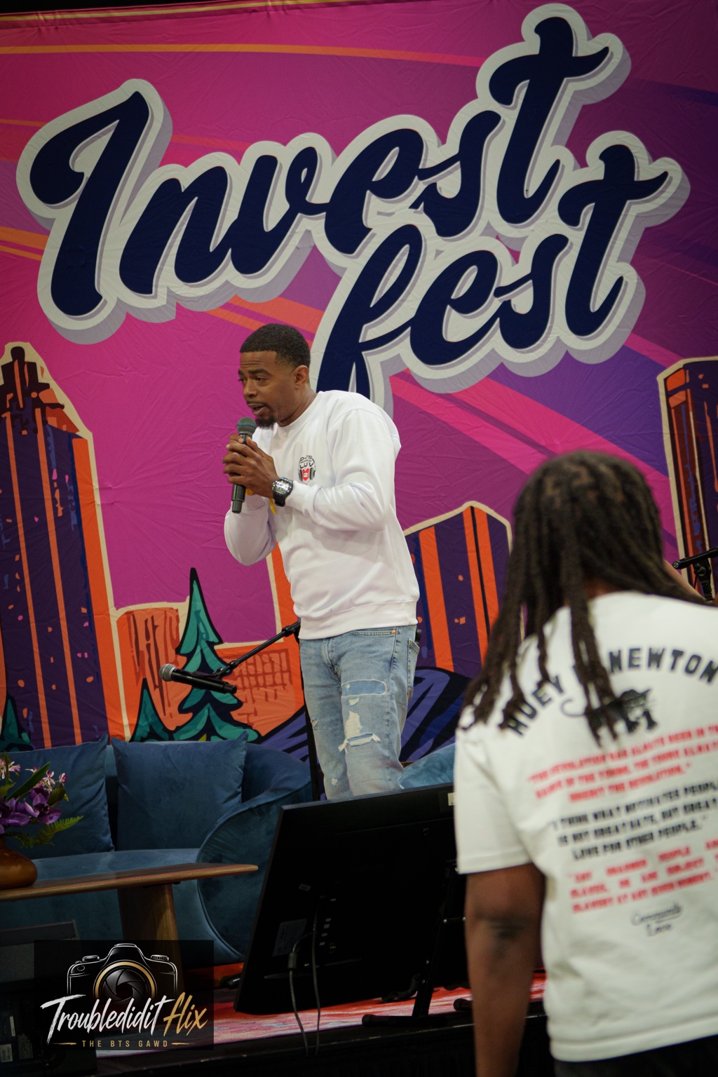 DJ Battio speaking on the microphone at Invest Fest